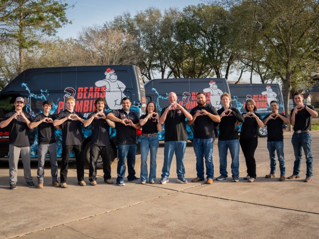 The Bear's Plumbing team standing proudly in front of their service vehicles, serving homeowners throughout Spring, Texas with professional plumbing services.